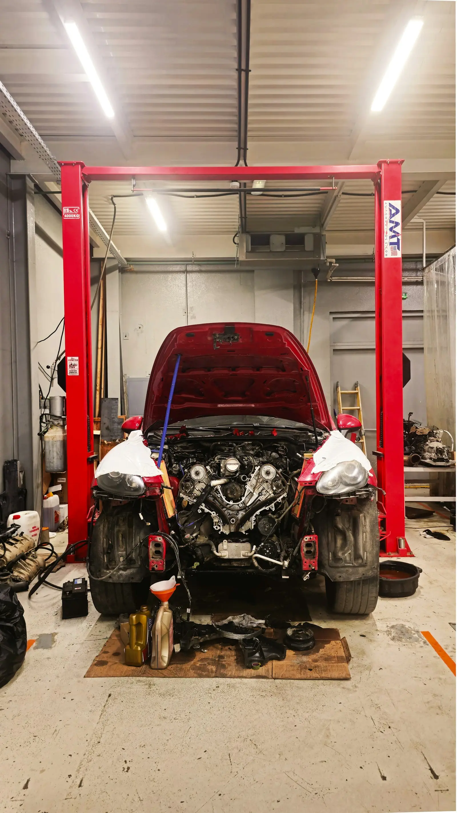 A car on the lift in a service bay with its hood open