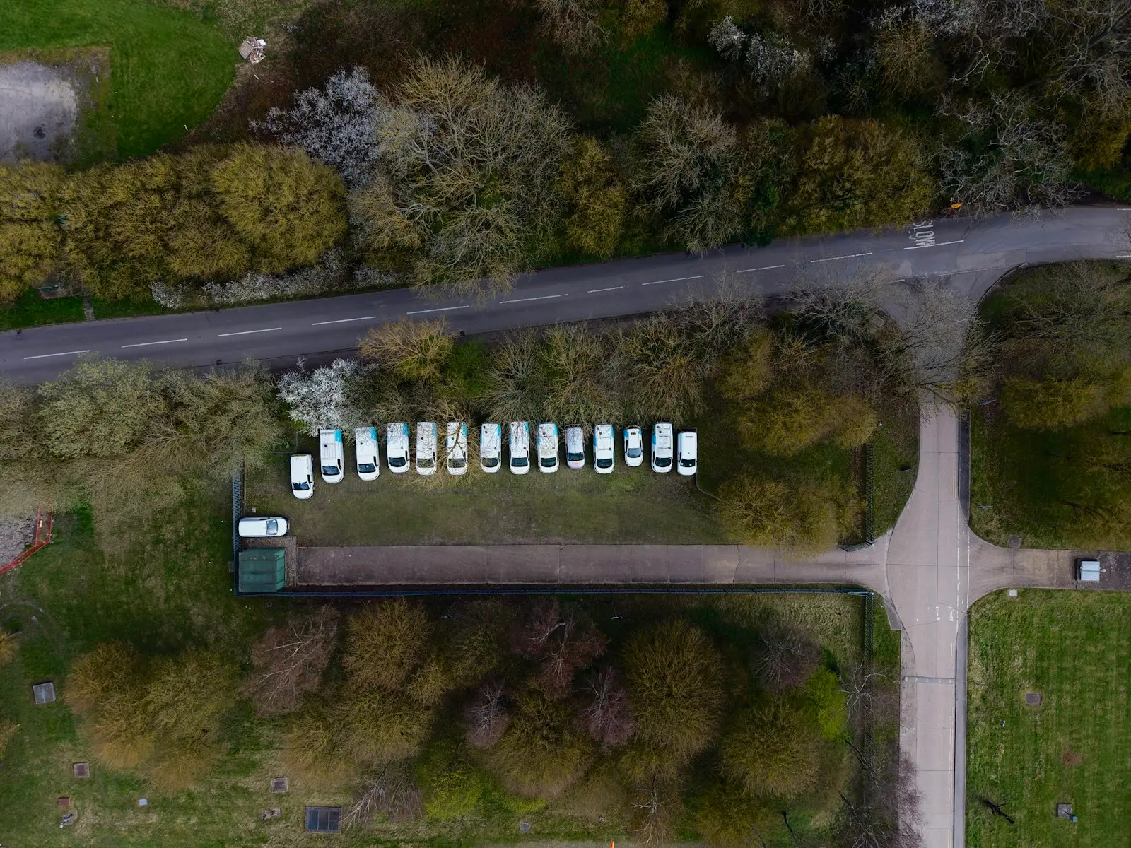 Row of white work vans parked together, seen from above