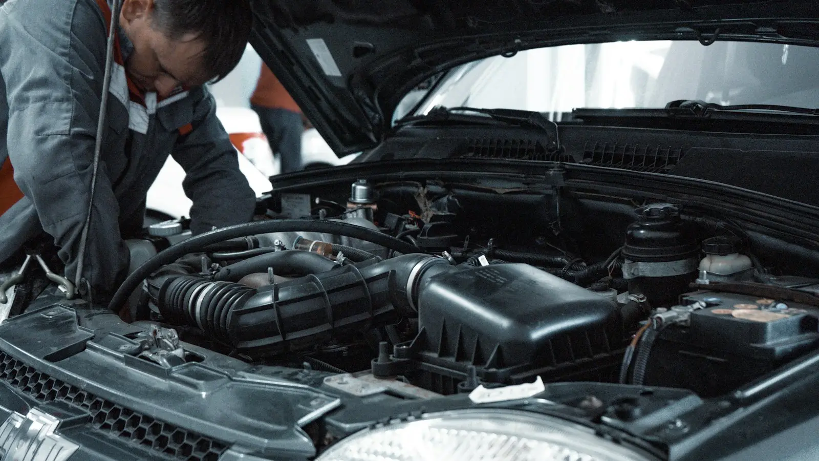 Mechanic inspecting a car engine with the hood open