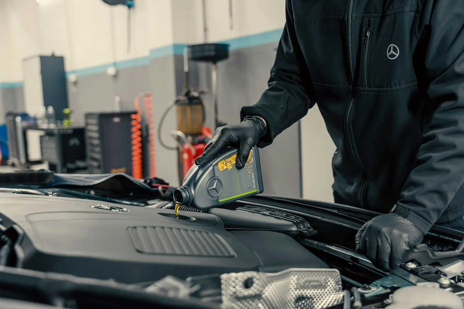 Mechanic pouring fresh oil into an engine during an oil service