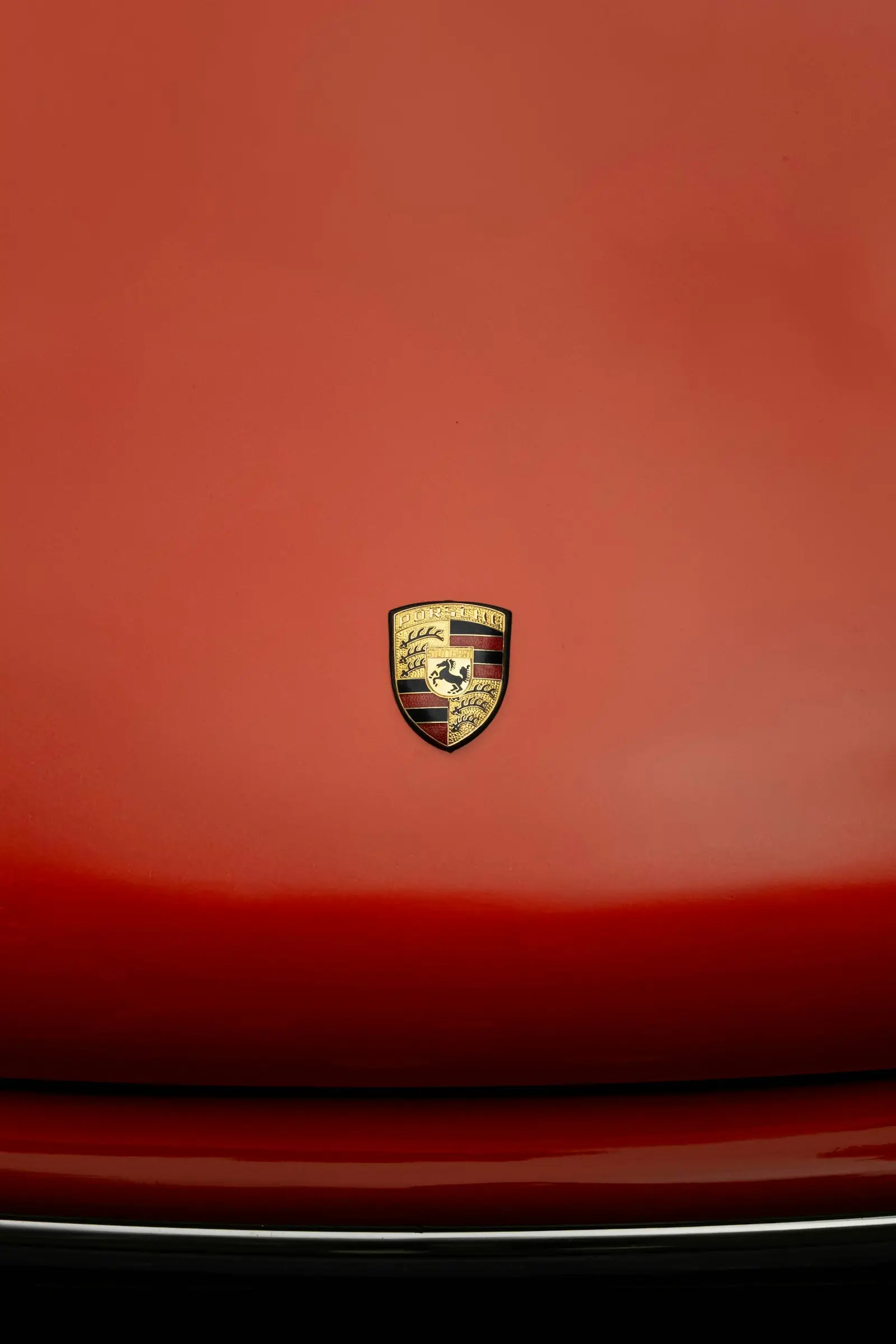 Porsche crest on a red hood