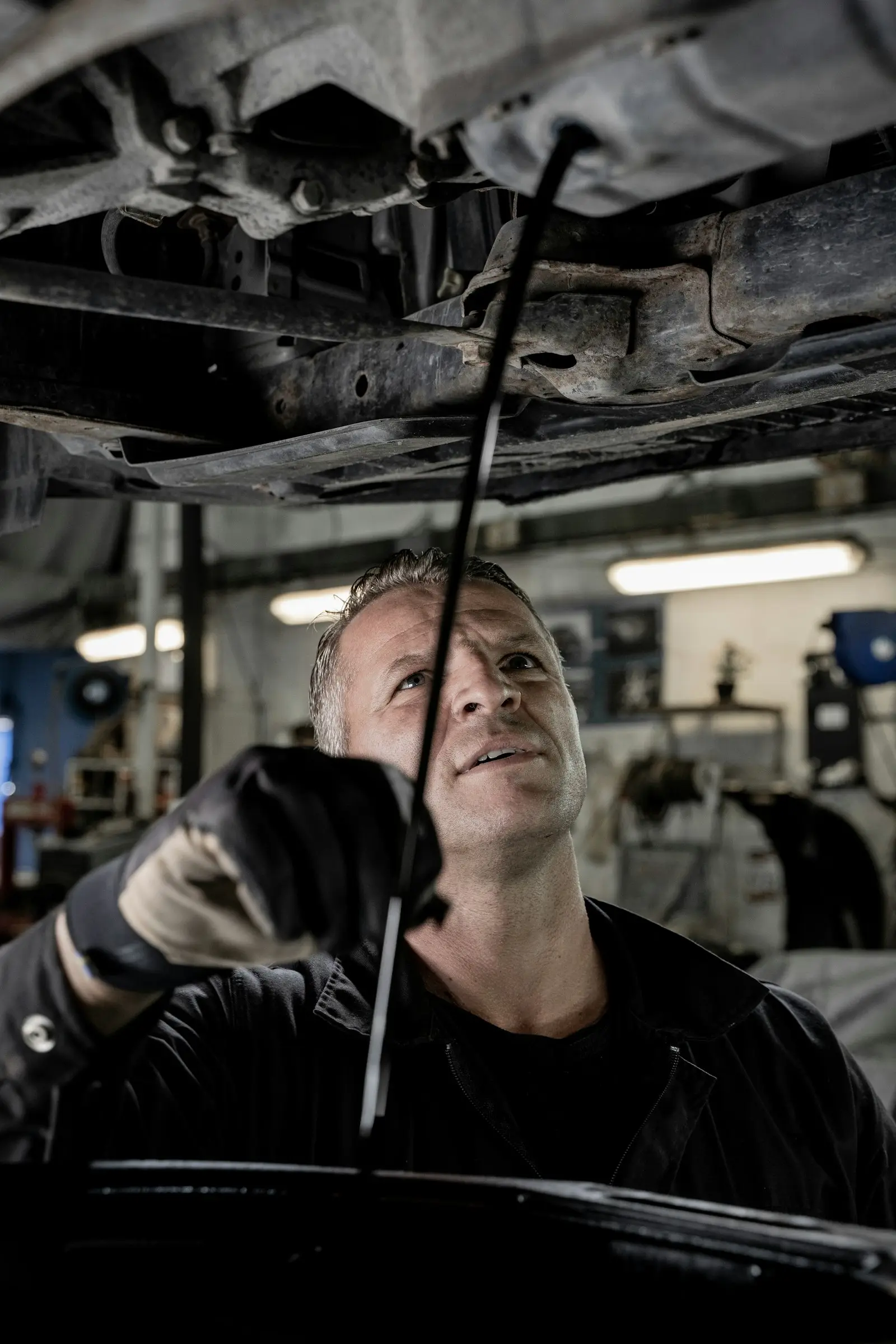 A technician working under a car on the lift